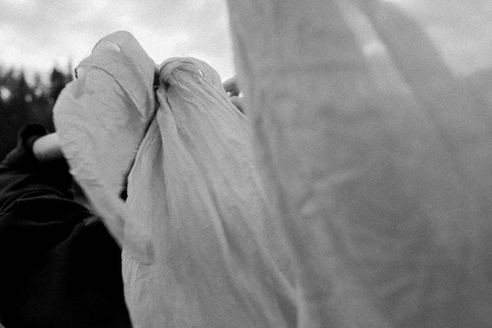 a black and white photo of a person holding a bag