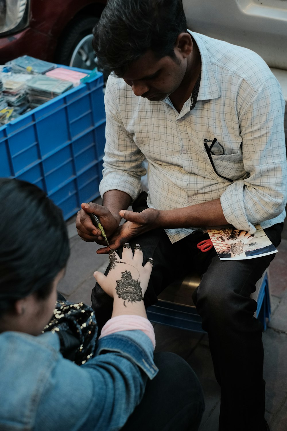 a man is getting a tattoo on his hand