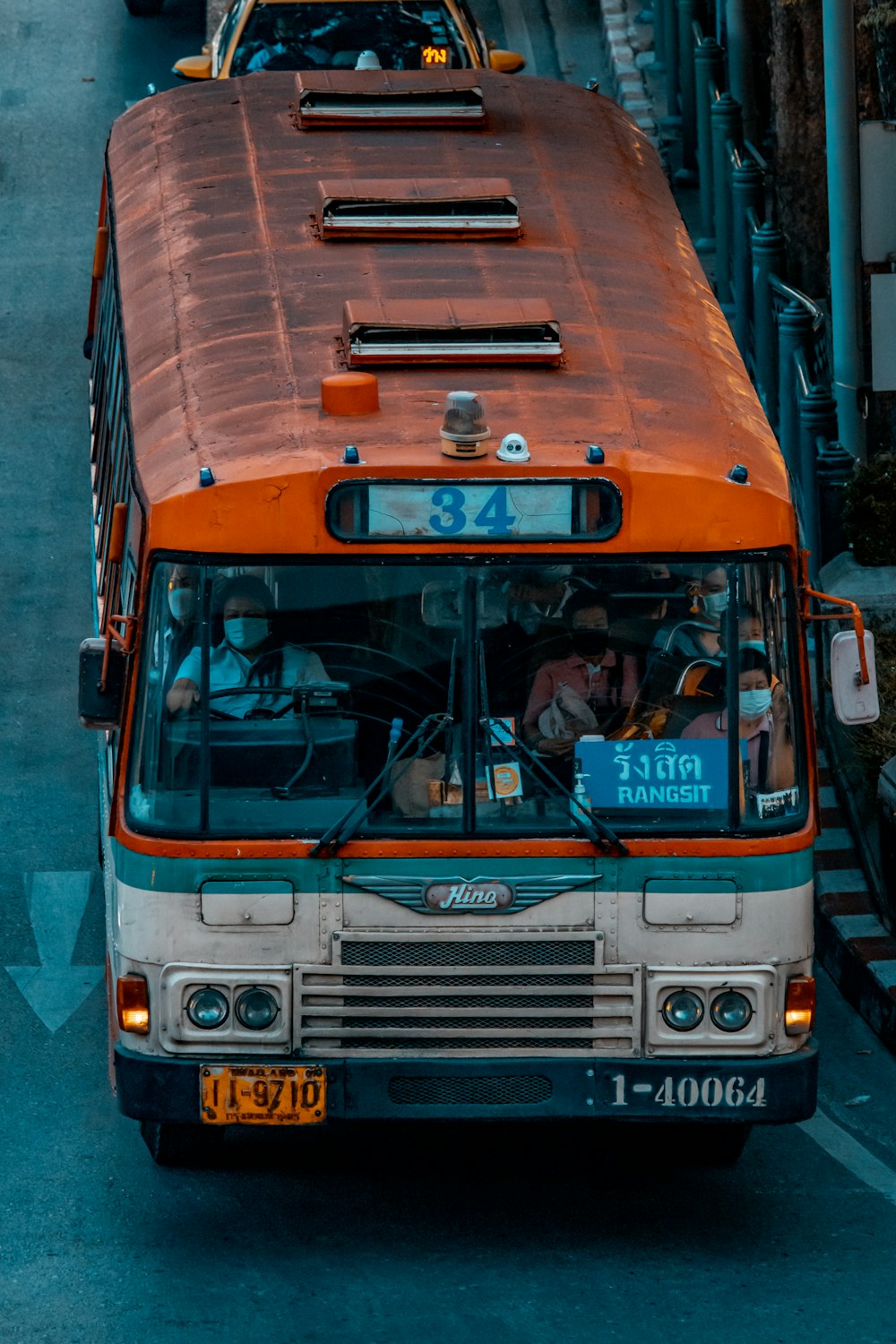 an orange and white bus driving down a street