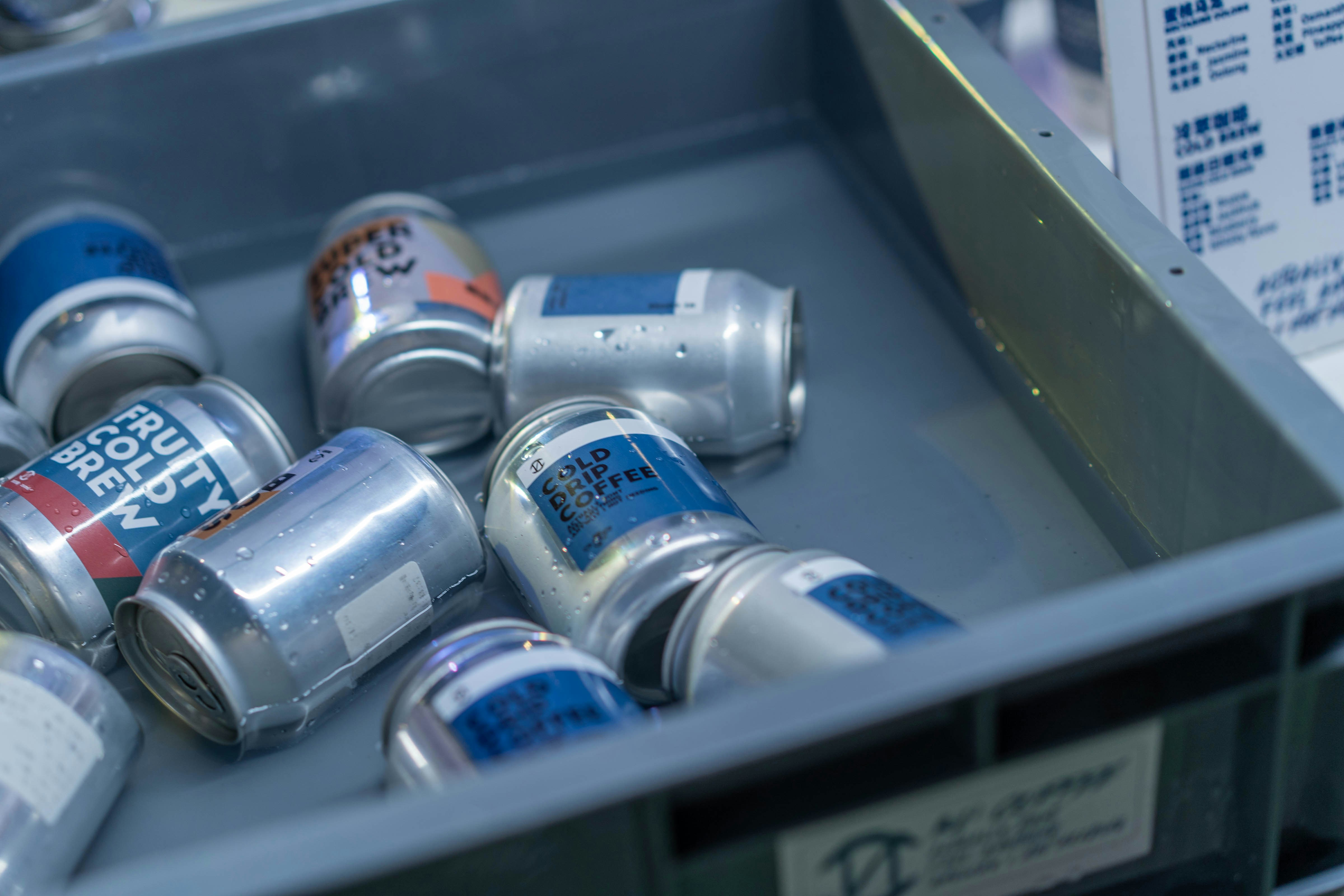 a metal bin filled with cans of soda