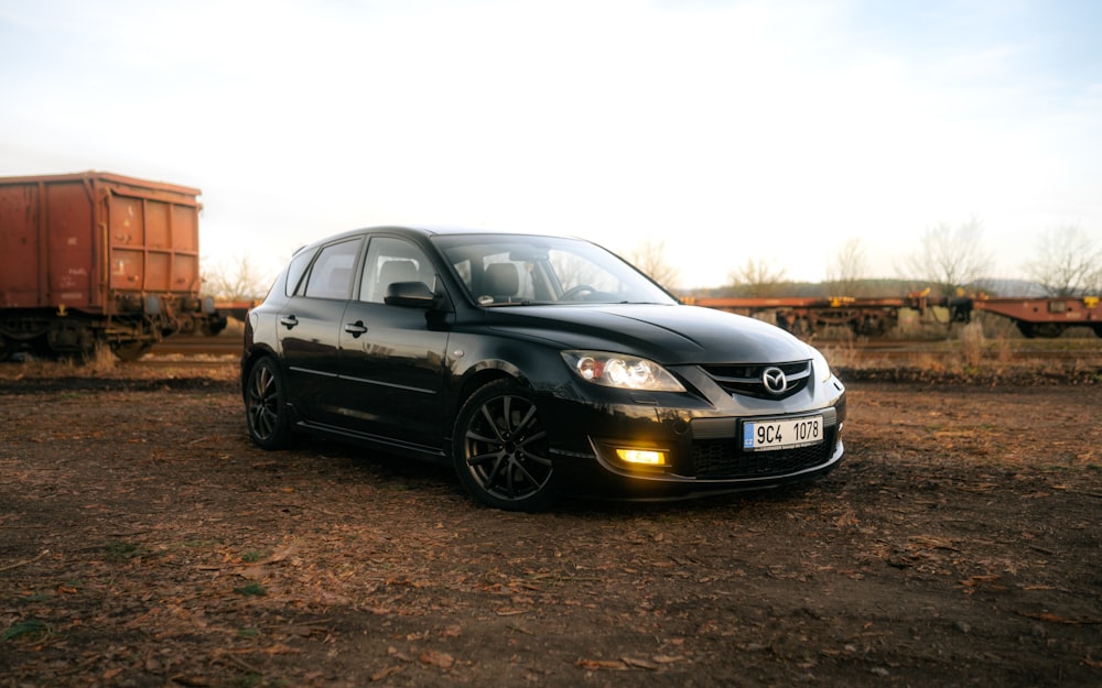 a black car is parked in a field