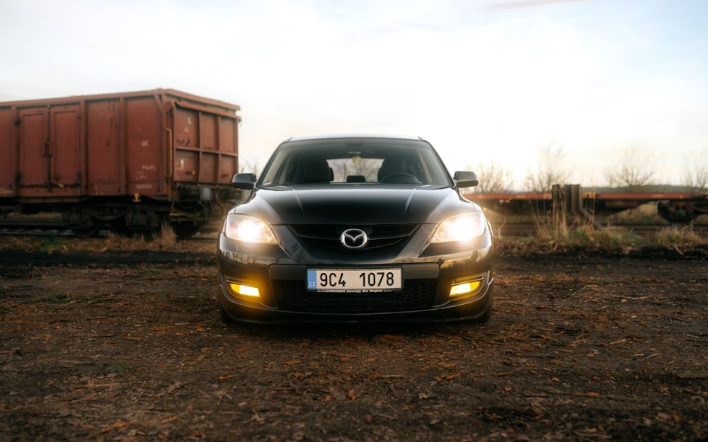 a black car is parked in front of a train