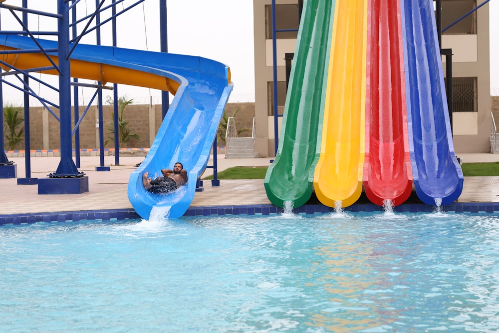 a person sliding down a water slide in a pool