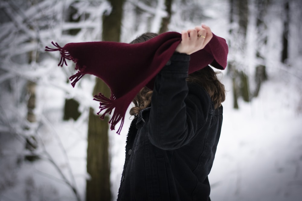 a woman wearing a maroon hat and scarf