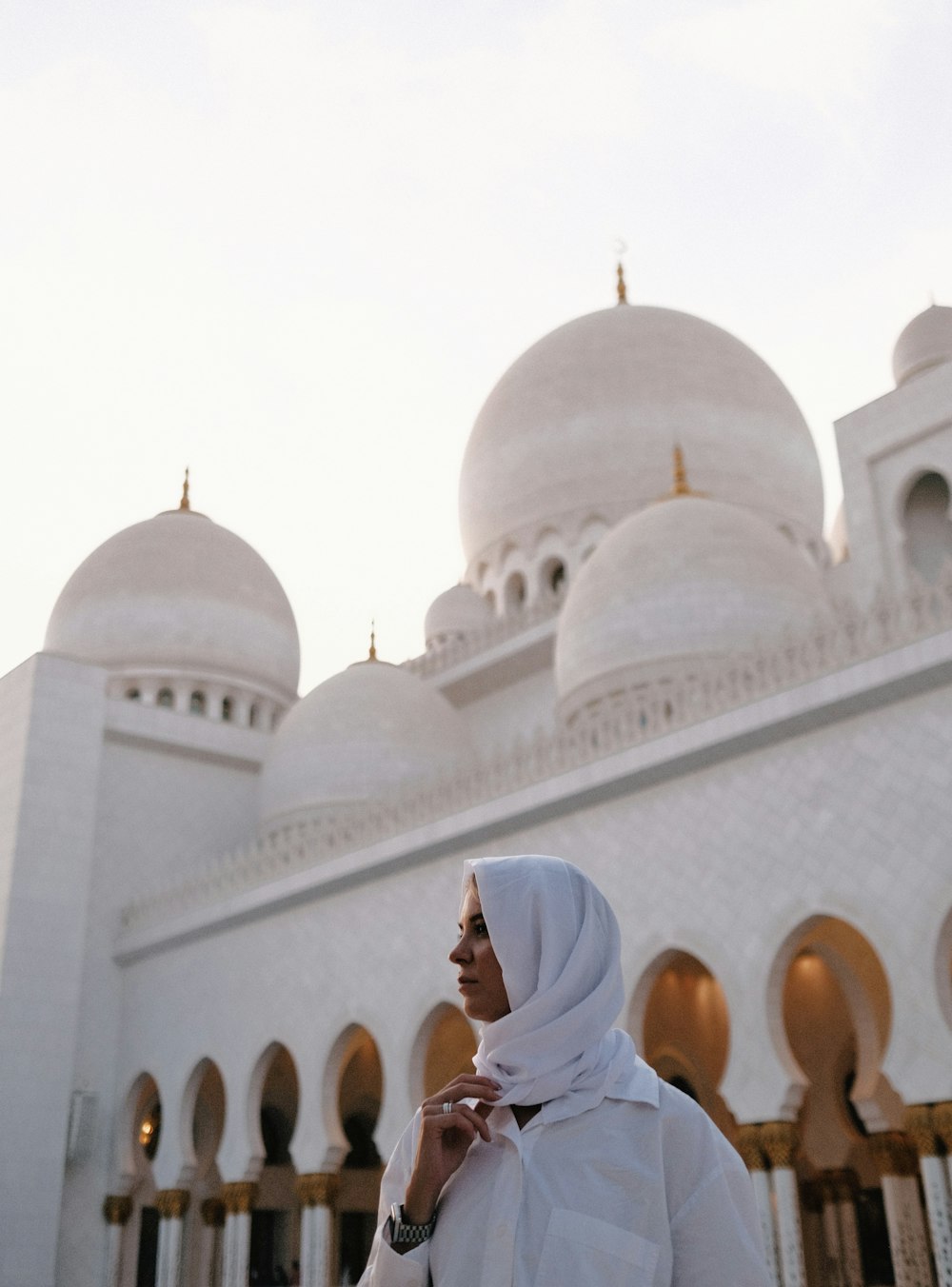 a woman standing in front of a white building