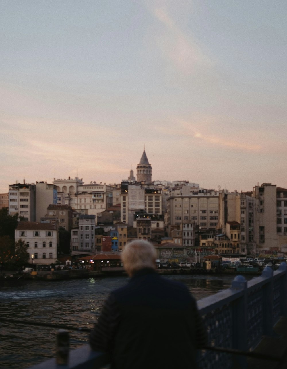 a man sitting on a bench looking at a city