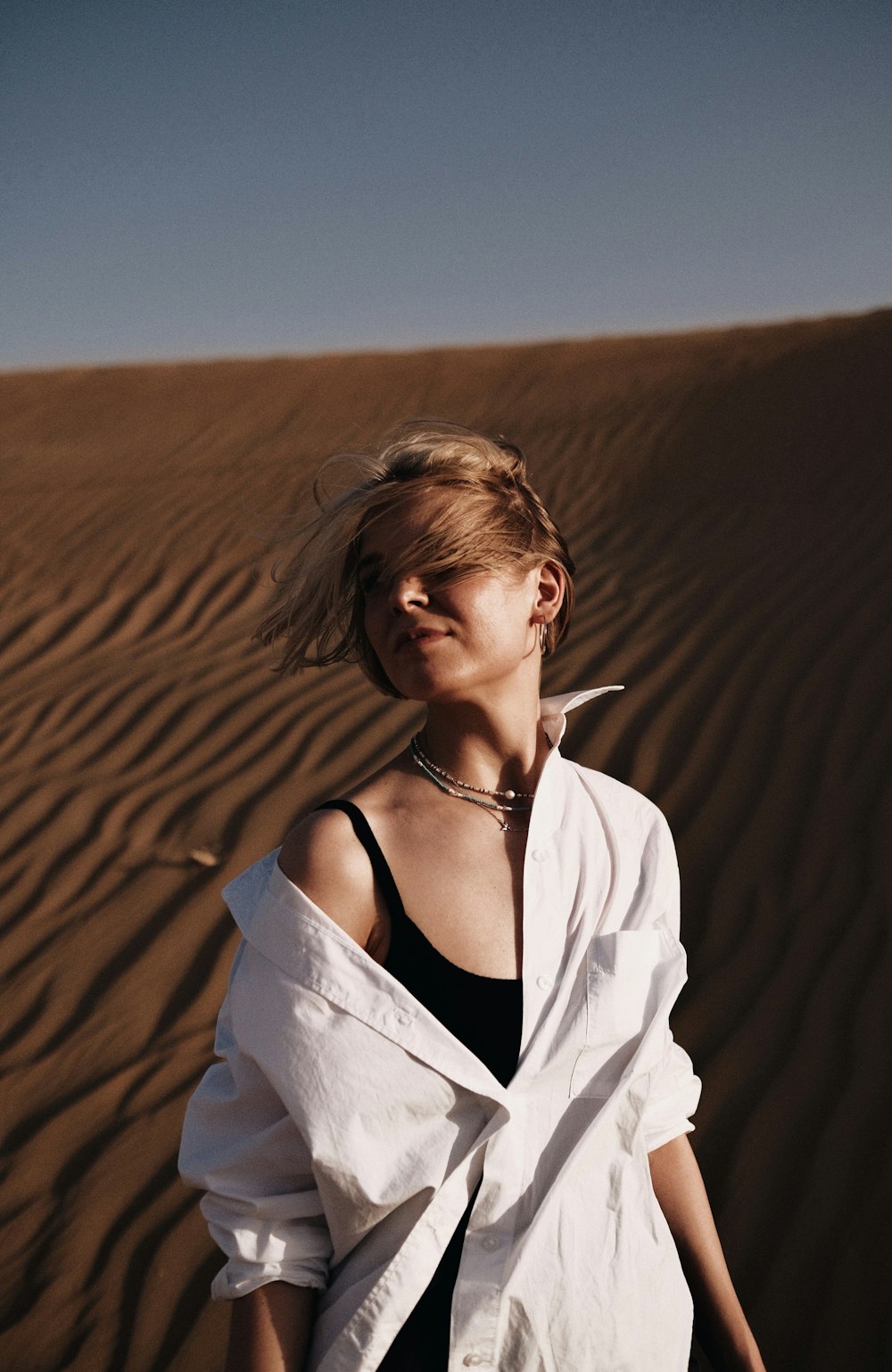 a woman standing in the middle of a desert