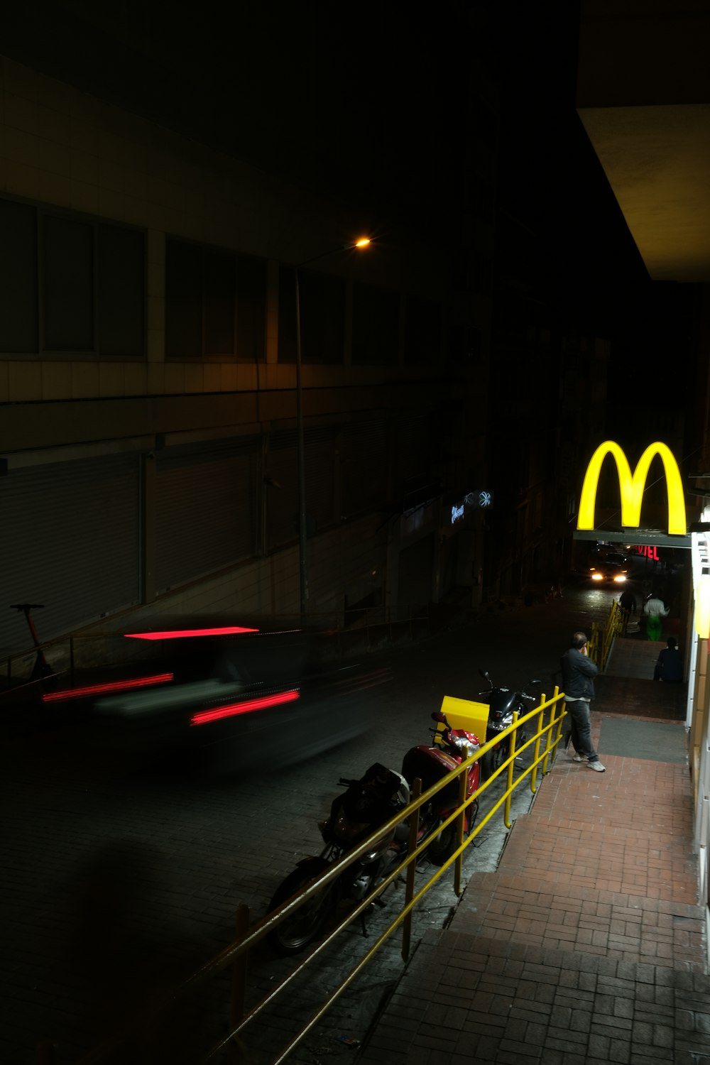 a man sitting on a bench in front of a mcdonald's