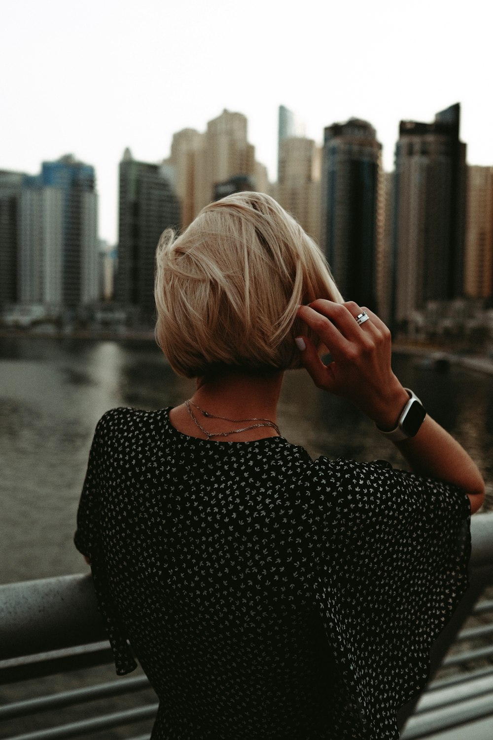 a woman standing on a bridge talking on a cell phone