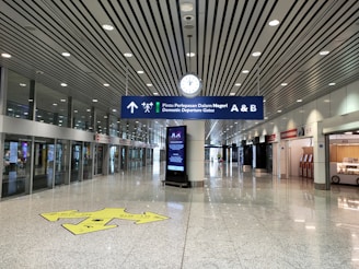Brightly lit airport directional signage guiding travelers inside a modern terminal.