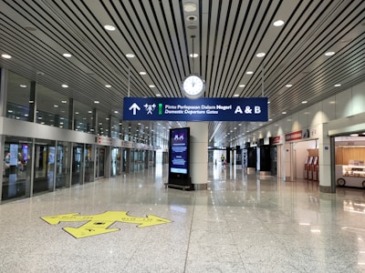 Brightly lit airport directional signage guiding travelers inside a modern terminal.