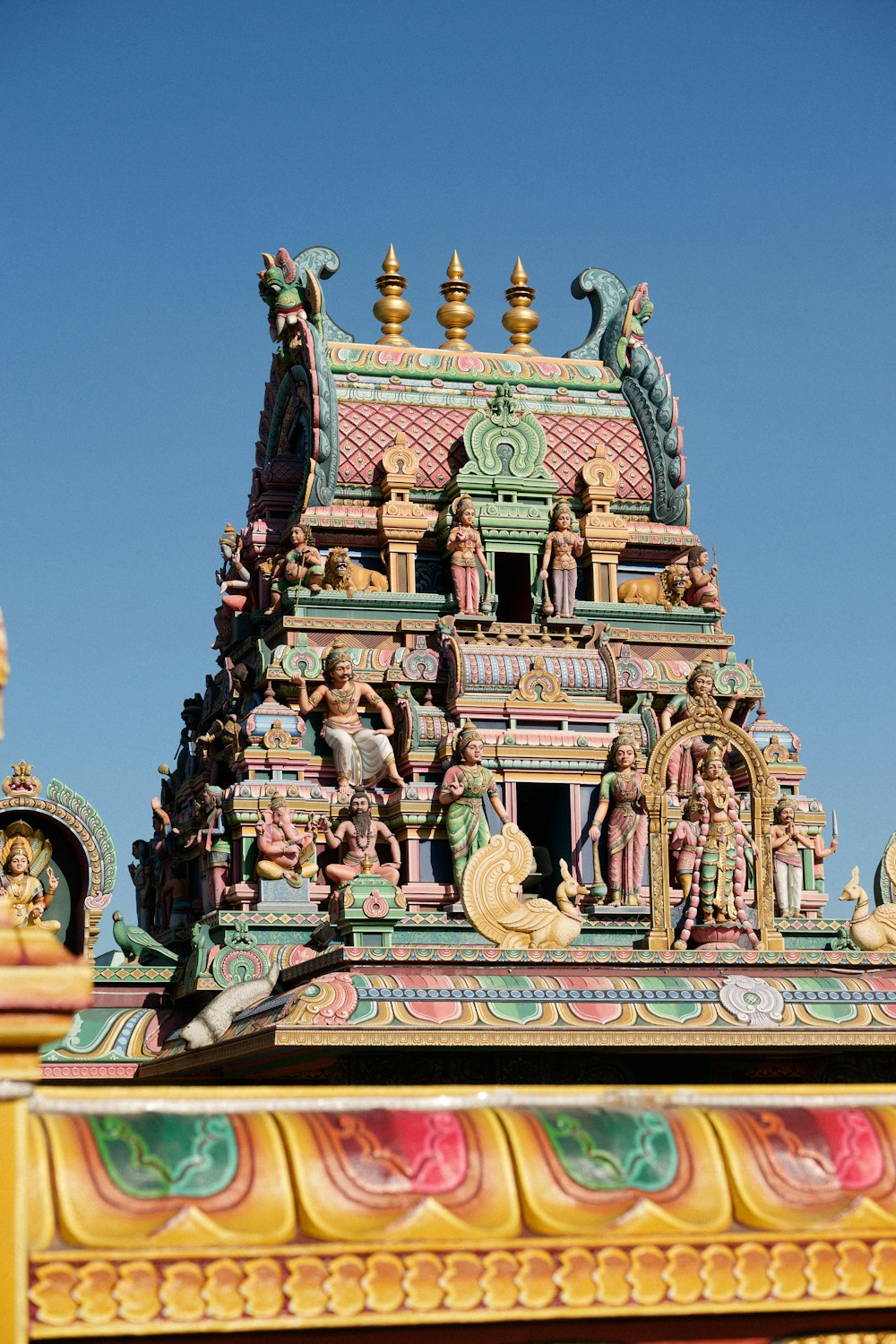 a colorful building with statues on top of it