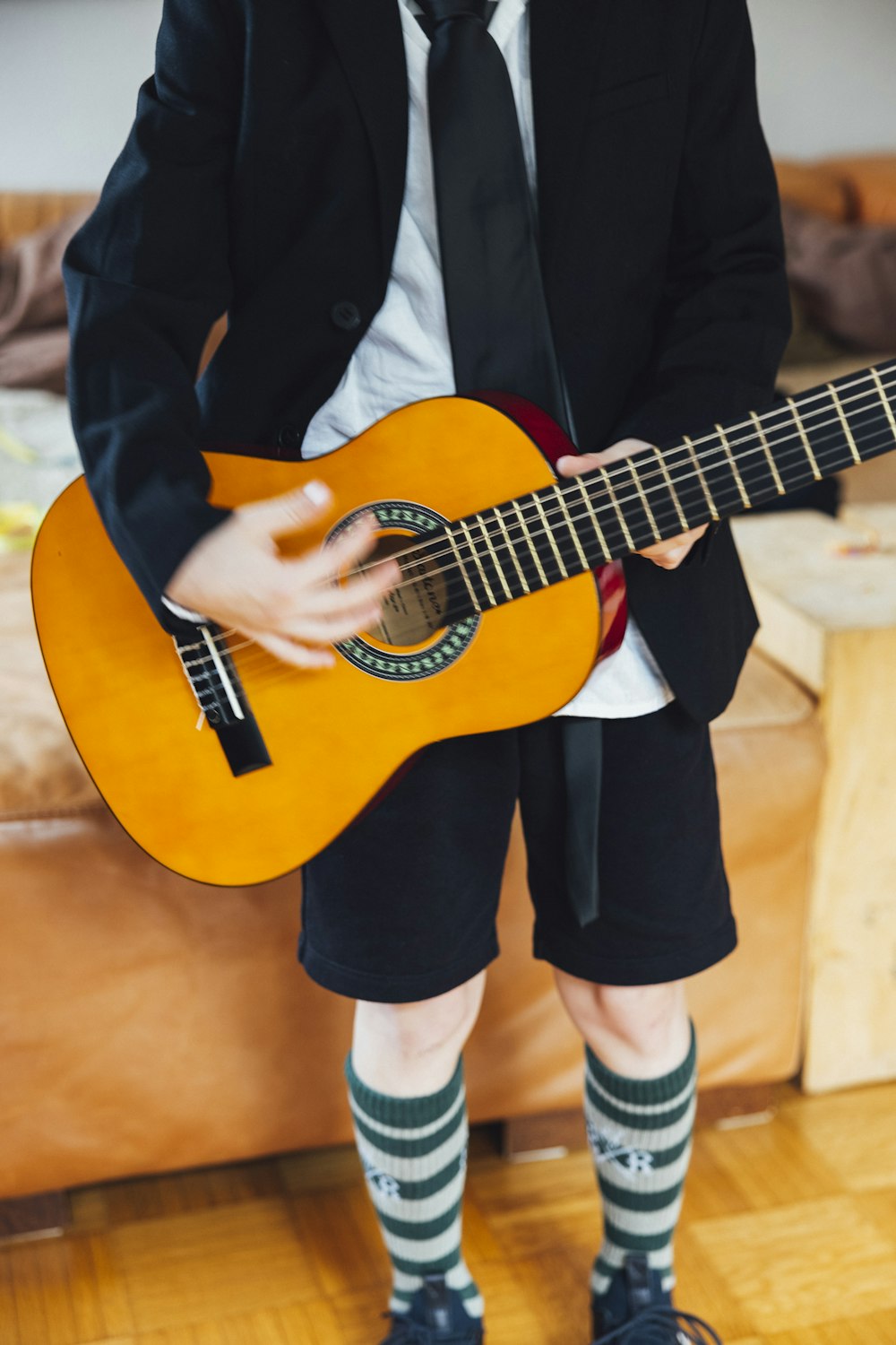 a boy in a suit and tie holding a guitar