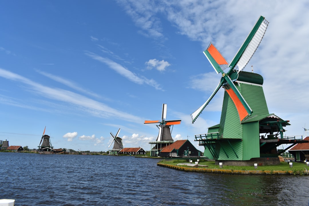 a group of windmills sitting next to a body of water,
