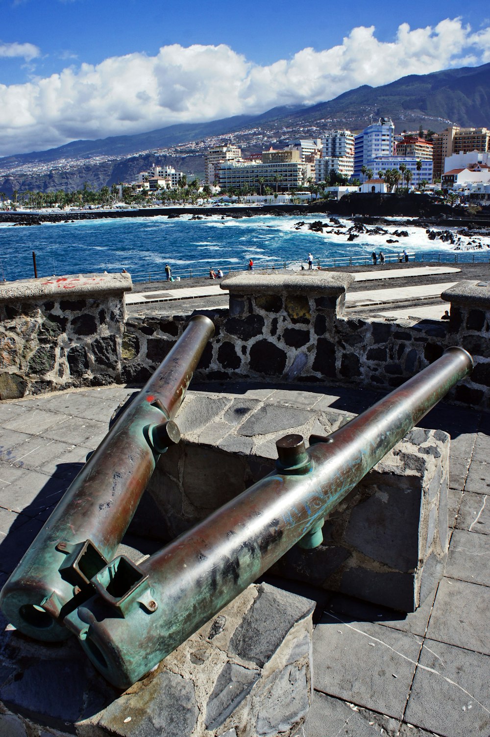 a large metal cannon sitting on top of a stone wall