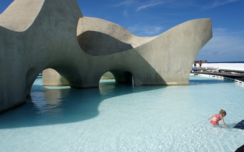 a woman in a pink bathing suit standing in a pool