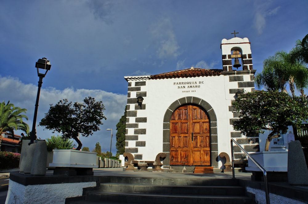 a white building with a wooden door and stairs