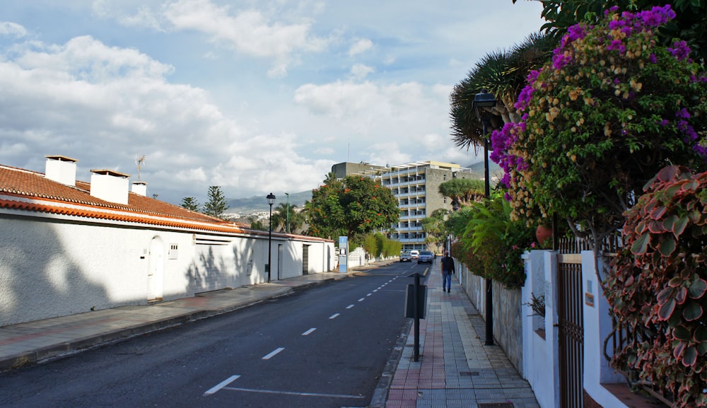 a person walking down a street next to tall buildings