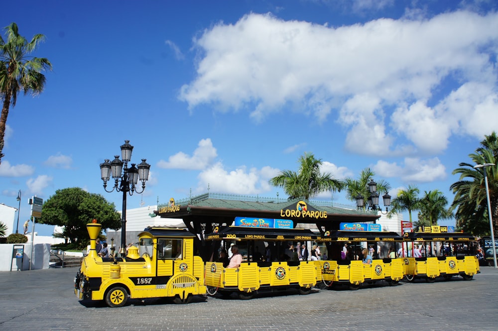 a group of people riding on the back of a yellow train