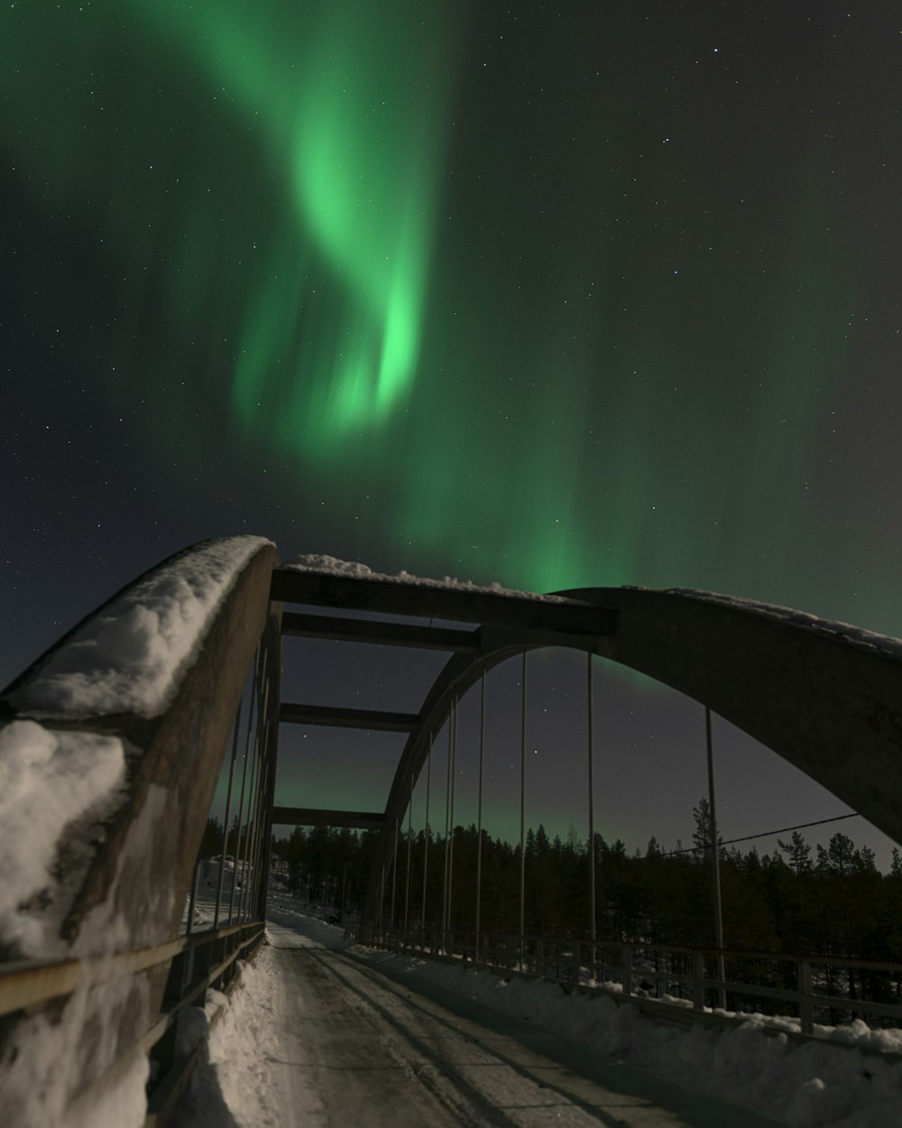 a bridge that has a green light in the sky
