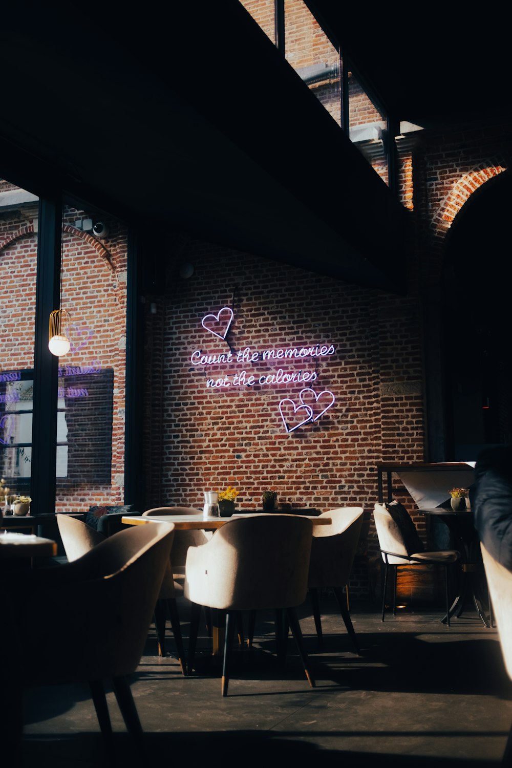 a restaurant with a brick wall and a neon sign