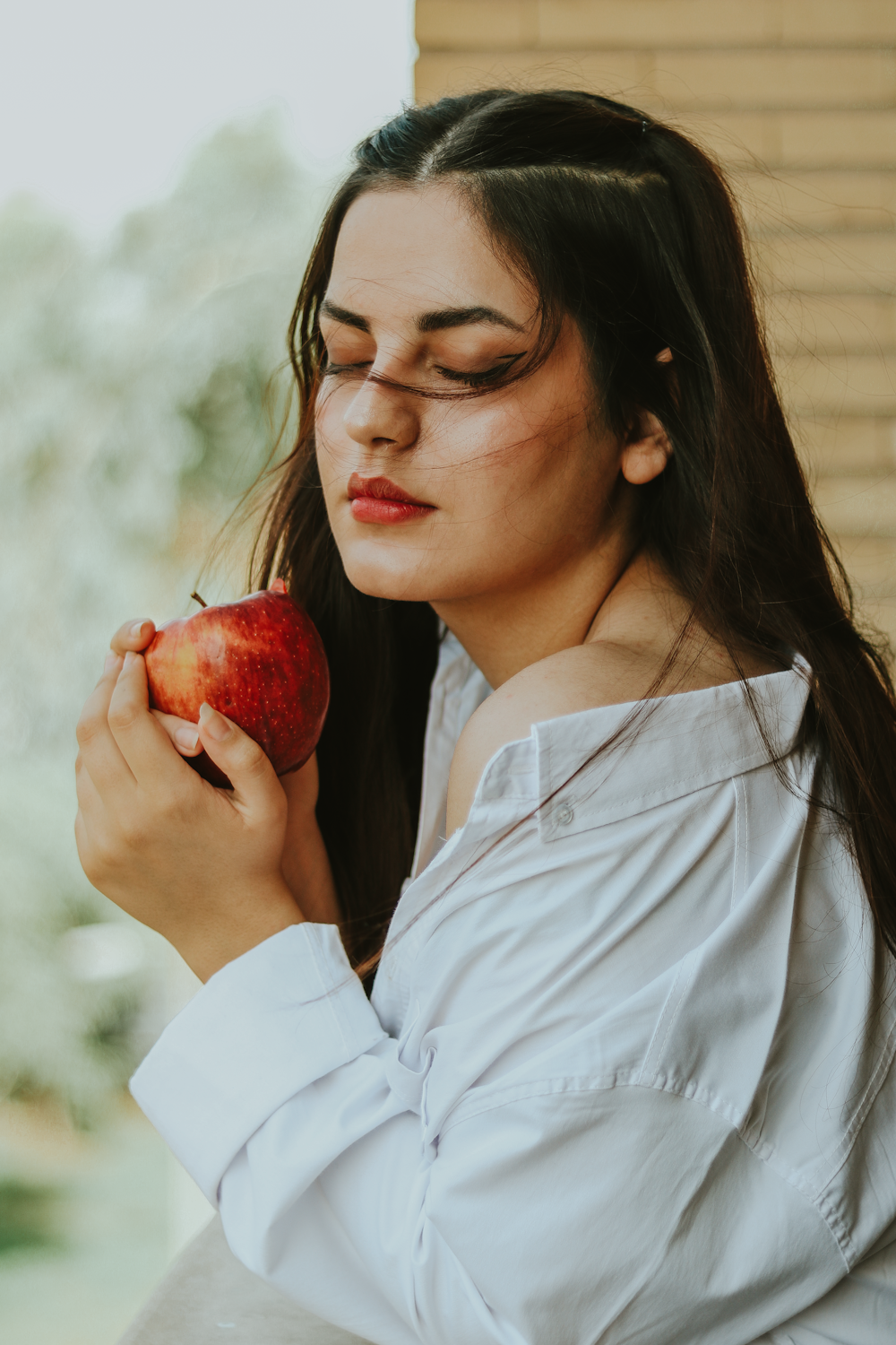 a woman holding an apple in her right hand
