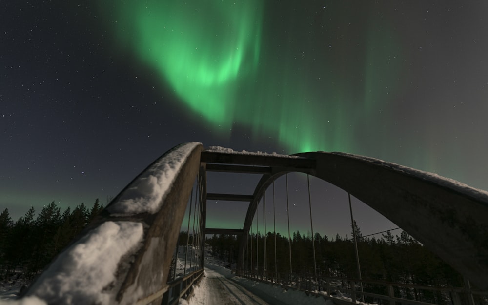 a bridge with a green light in the sky