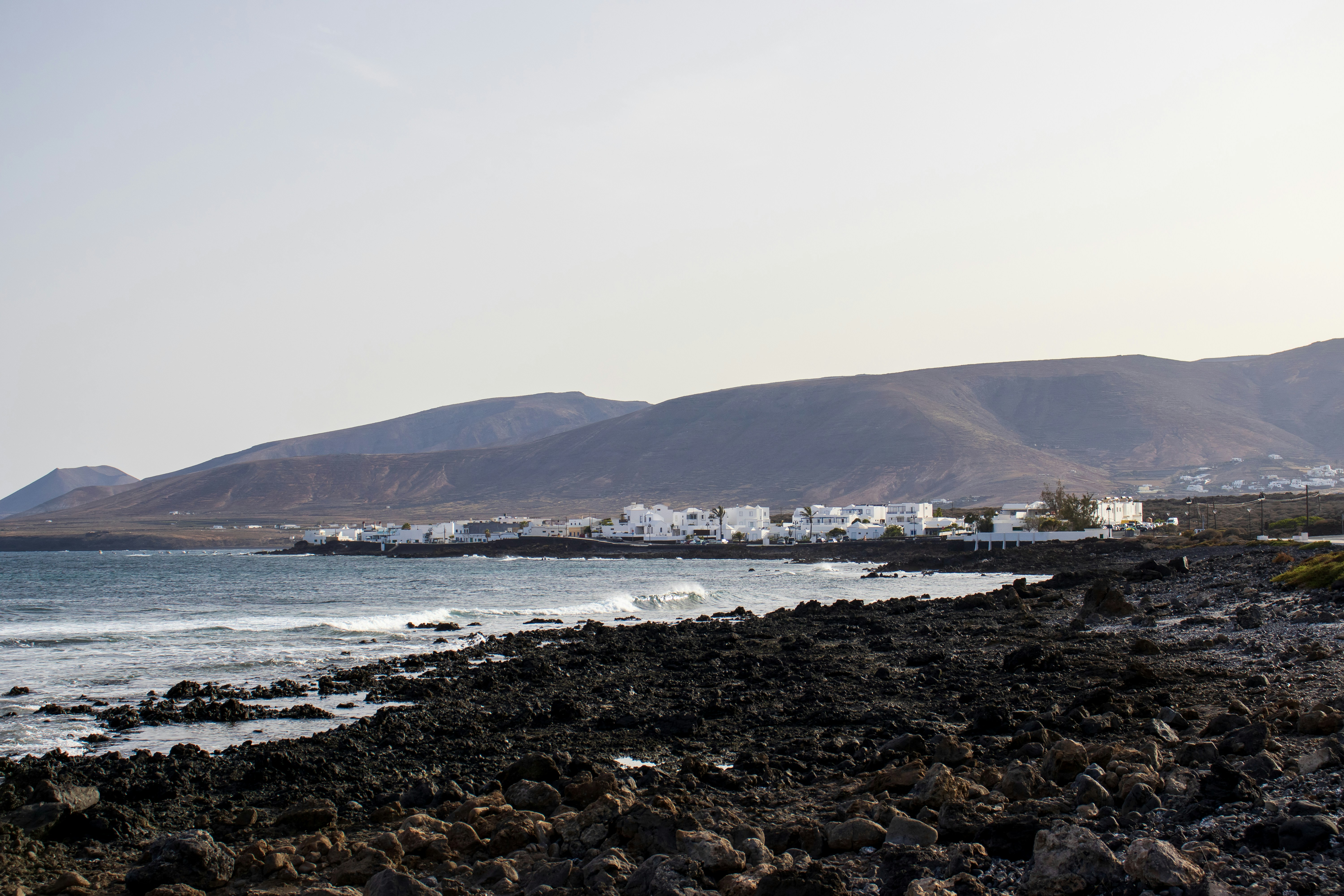 a rocky beach with a mountain in the background