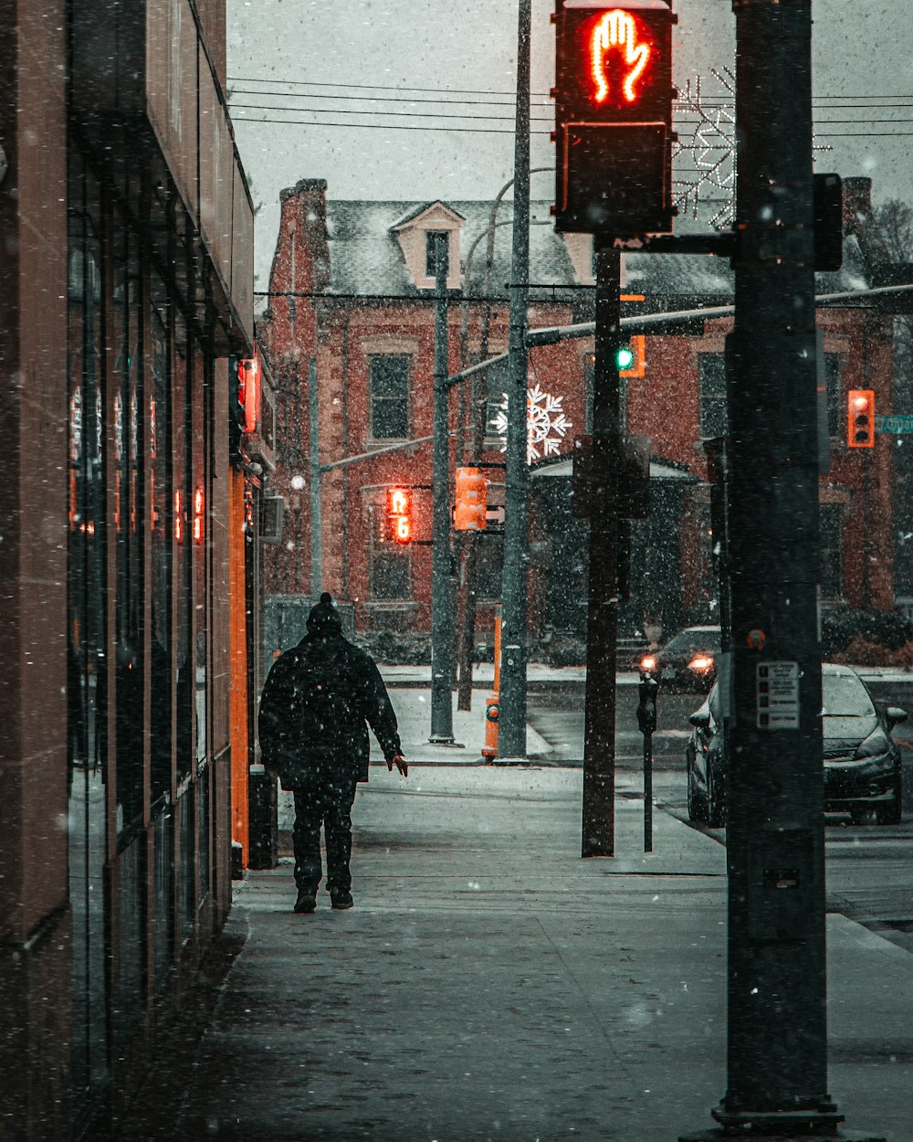 a man walking down a street next to a traffic light