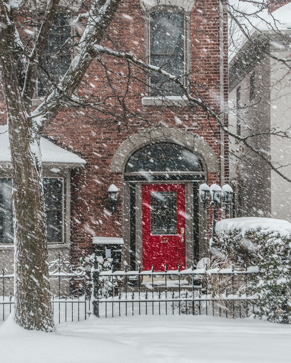 a red door in front of a red brick house
