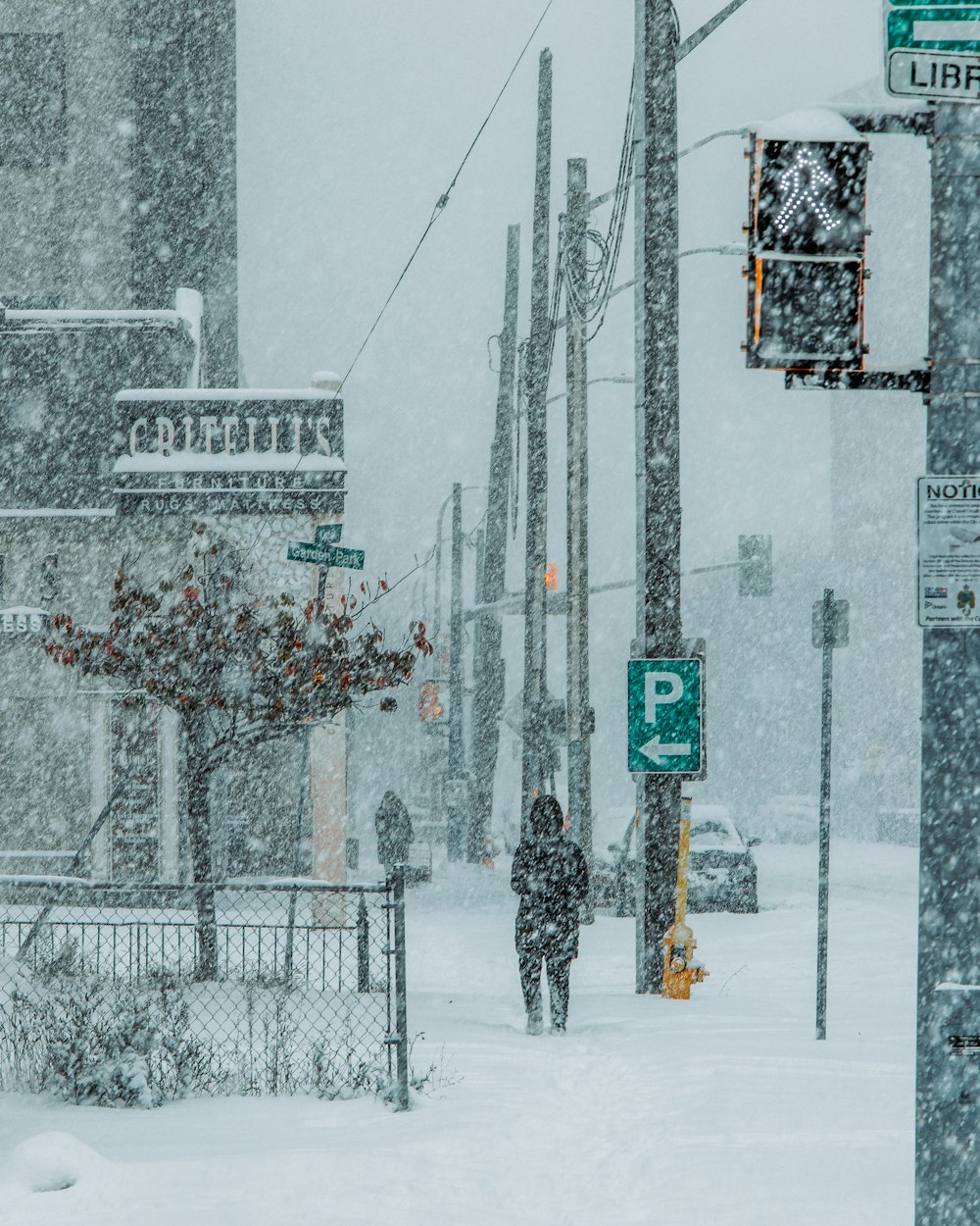 a person walking down a street in the snow