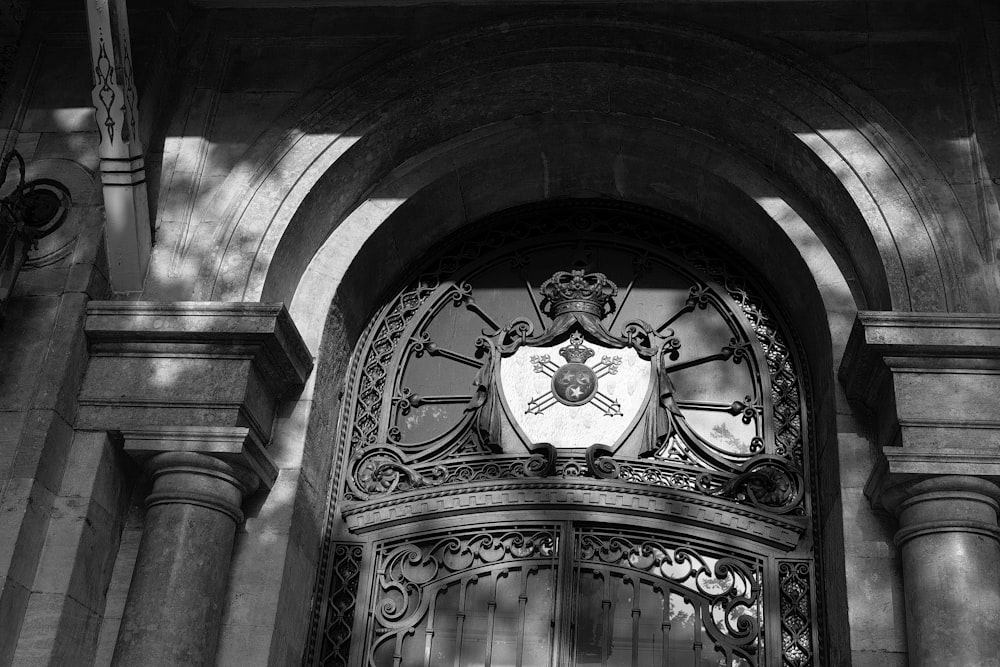 a black and white photo of a door with a coat of arms on it
