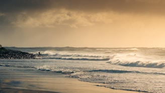 A vibrant scene of surfers catching waves under a golden sunset on a lively beach.