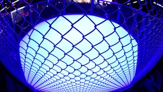 a close up of a metal fence with a blue light