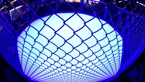 a close up of a metal fence with a blue light