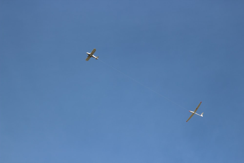 two airplanes are flying in the blue sky