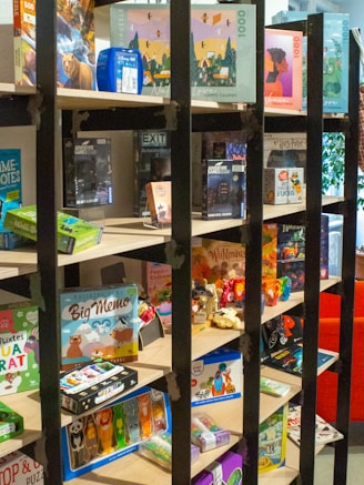 A colorful display of various toys and games on a wooden shelf.