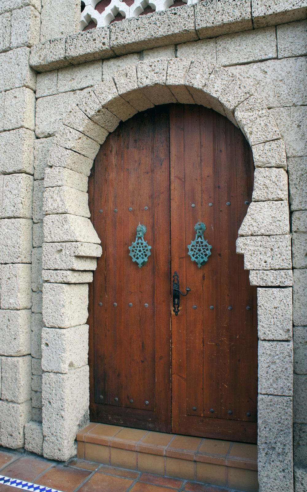 a large wooden door with a decorative arch