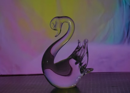A stunning ice sculpture of a swan glistening under soft lighting at an elegant event.