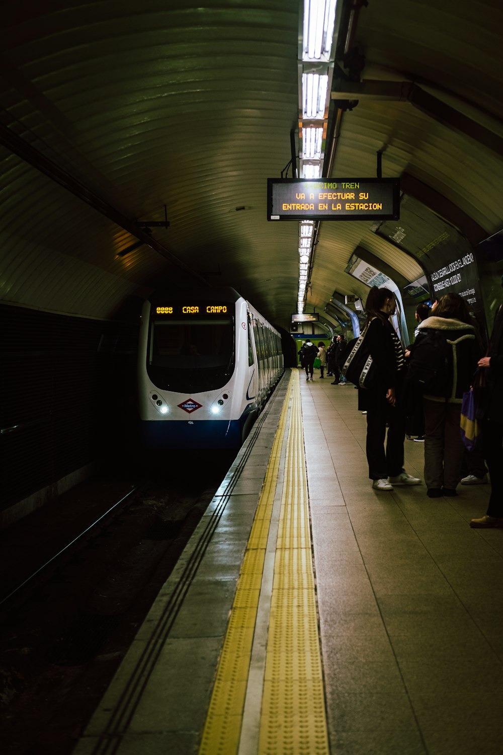 Un tren que se detiene en una estación de tren junto a una plataforma