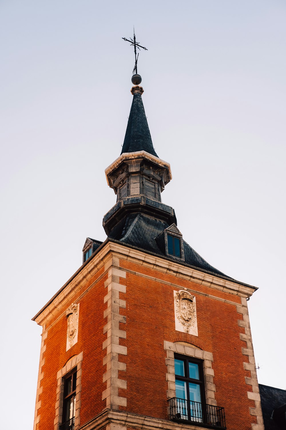 a tall brick building with a cross on top