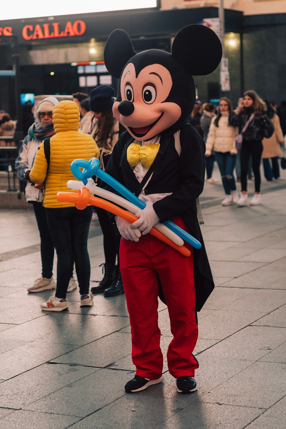 Un hombre con un disfraz de Mickey Mouse sosteniendo cepillos de dientes