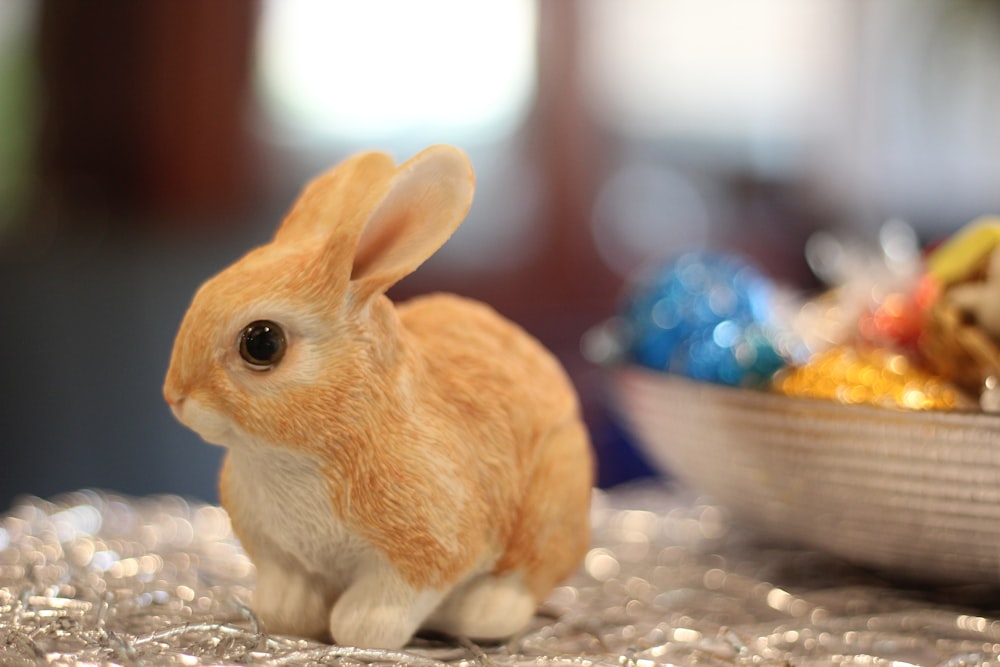 a toy rabbit sitting next to a bowl of candy