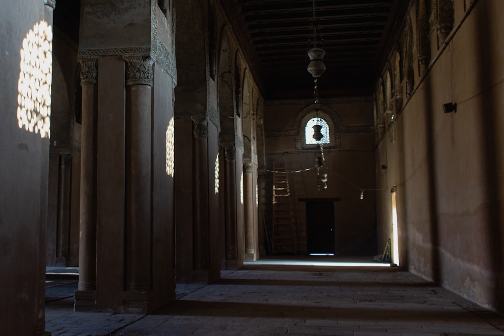 a long hallway with columns and a window