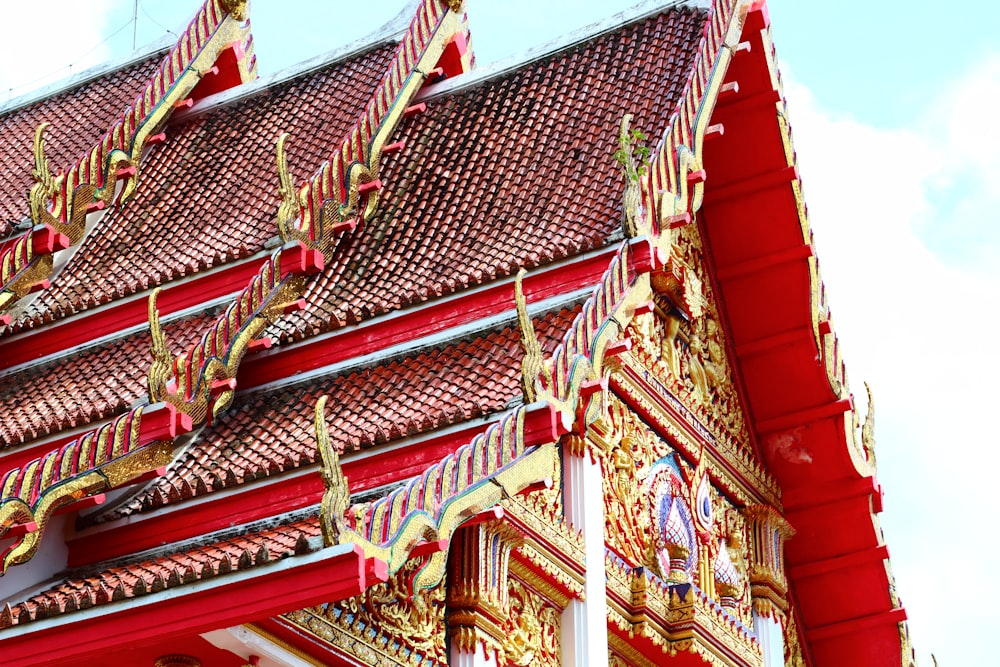 a red and gold building with a clock on it's side