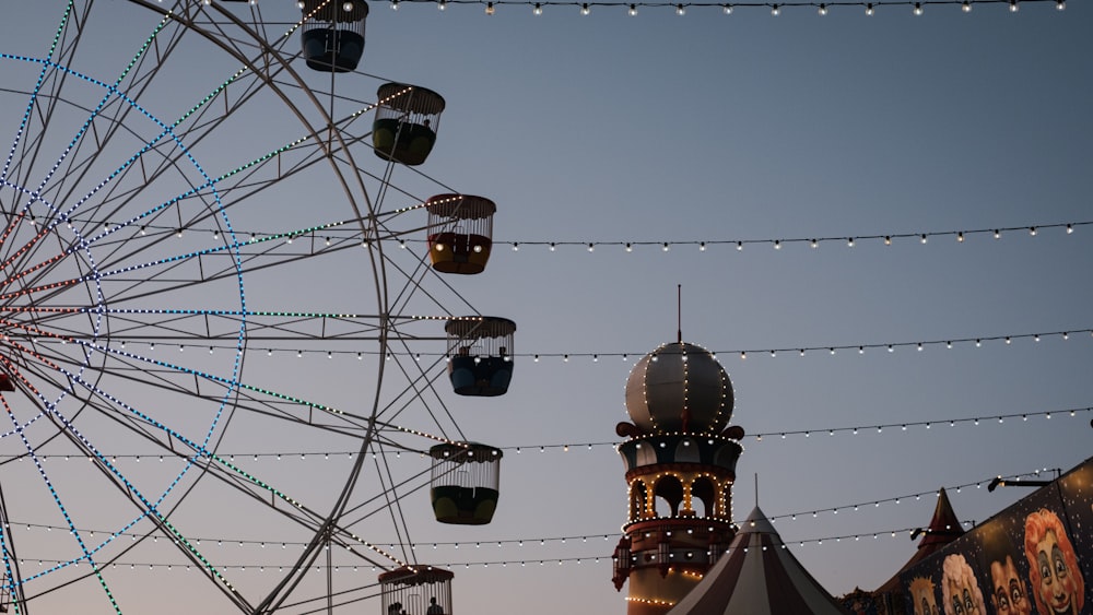 a ferris wheel with lights hanging from it's sides