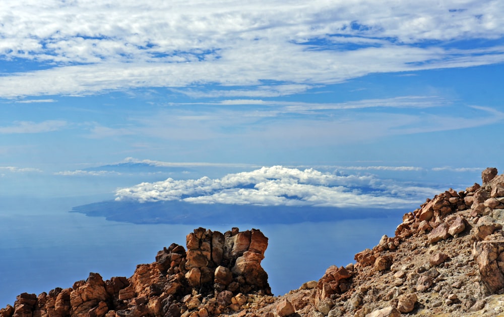 a view of a rocky mountain with clouds in the background