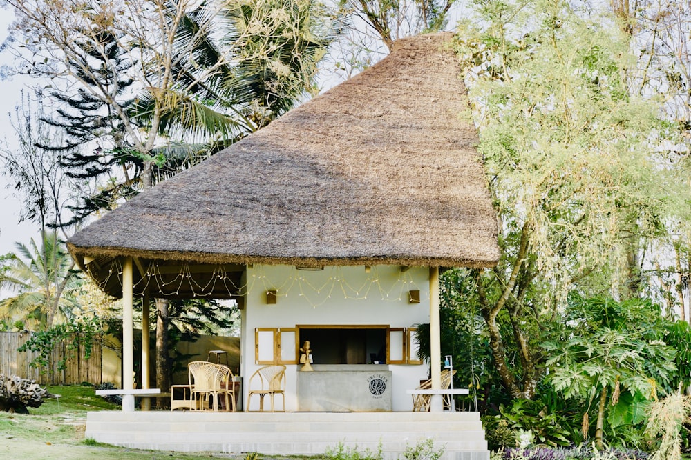 a small white house with a thatched roof