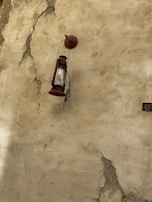 Rusty lantern hanging from a twisted iron hook outside a forgotten cabin.