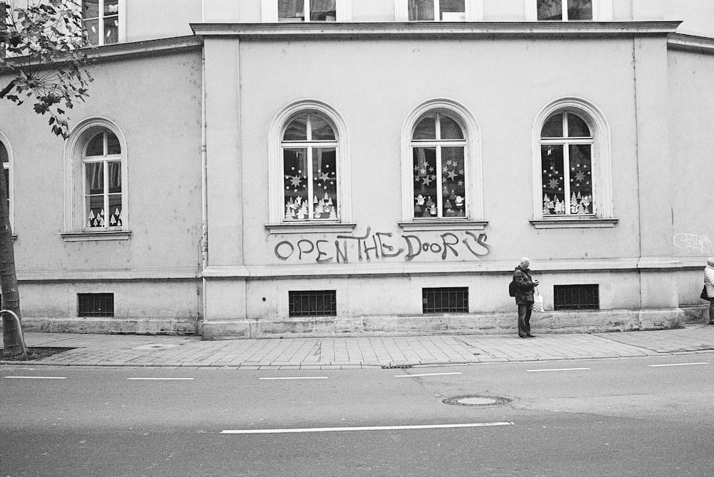 a man standing in front of a building with graffiti on it